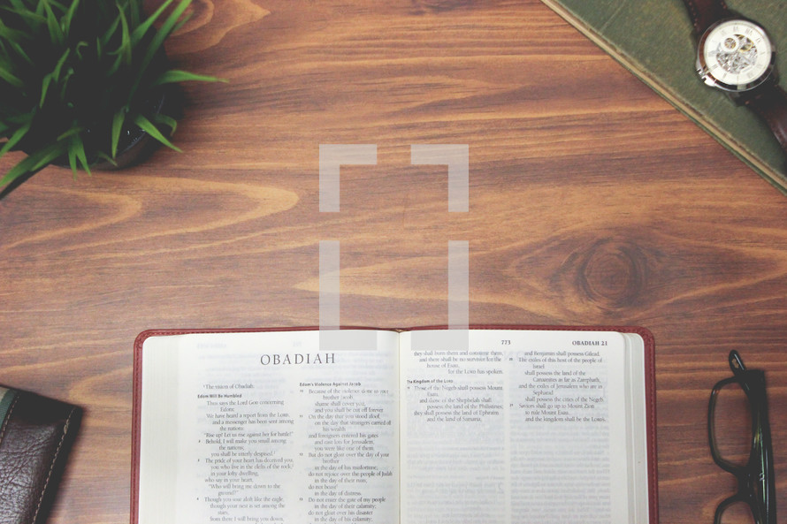 open Bible and reading glasses on a wood table - Obadiah 