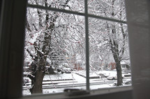 View of a snow covered street through a window.