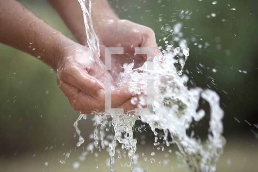 Clean water splashing in cupped hands.