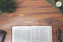open Bible and reading glasses on a wood table - Judges 