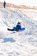 child sledding on a snow day