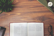 open Bible and reading glasses on a wood table - Titus 
