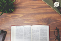 open Bible and reading glasses on a wood table - 1 Timothy 