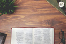open Bible and reading glasses on a wood table - Amos 