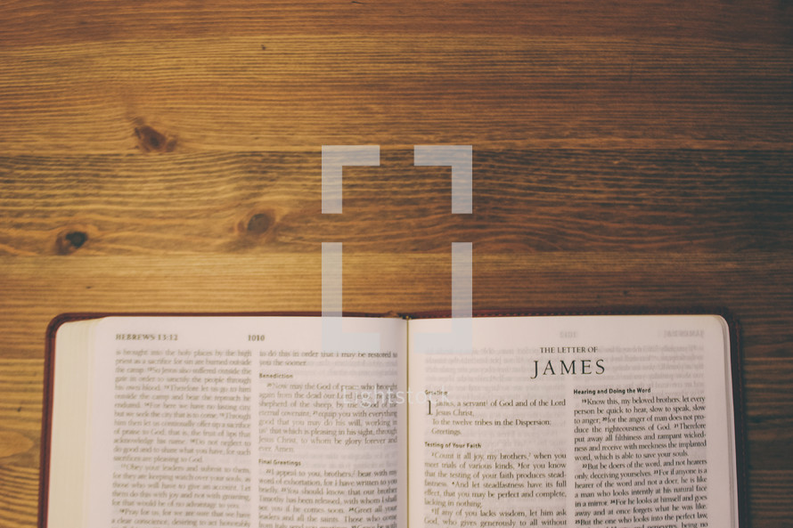 Bible on a wooden table open to the book of James.