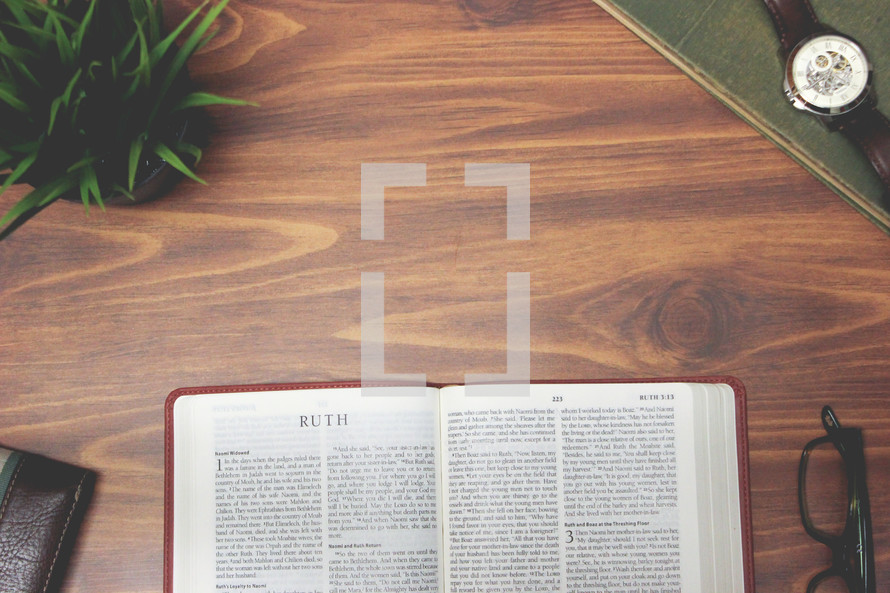 open Bible and reading glasses on a wood table - Ruth 