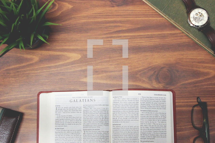 open Bible and reading glasses on a wood table - Galatians 
