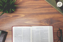 open Bible and reading glasses on a wood table - Leviticus 
