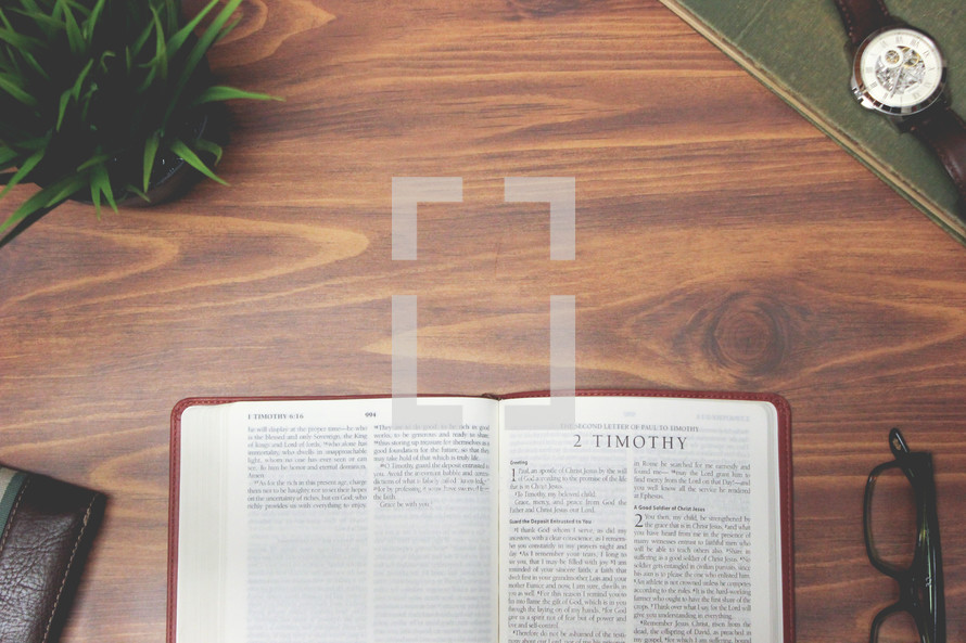 open Bible and reading glasses on a wood table - 2 Timothy 