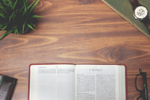 open Bible and reading glasses on a wood table - 1 Kings 