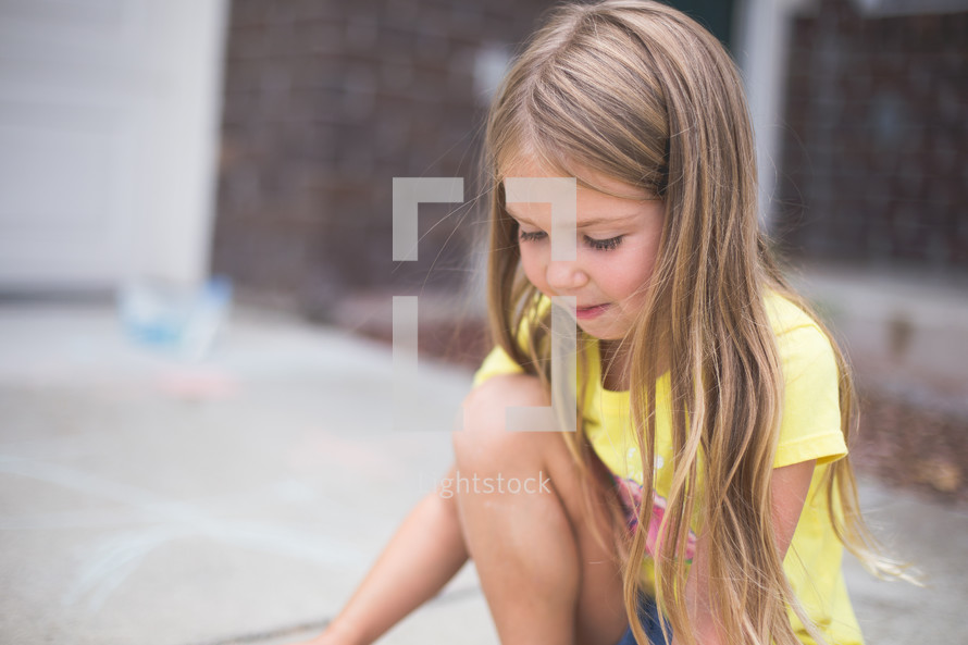 A young girl sits and plays.