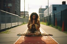 Beautiful young woman with curly hair praying on the street