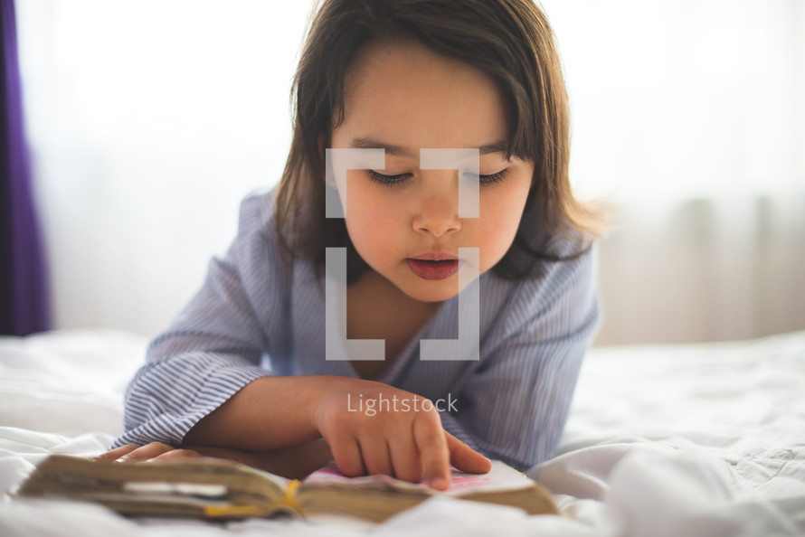 a child reading a Bible 