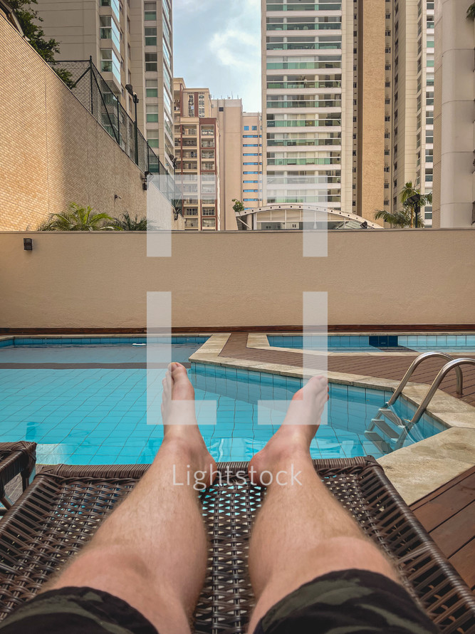 Man relaxing by the pool in urban setting