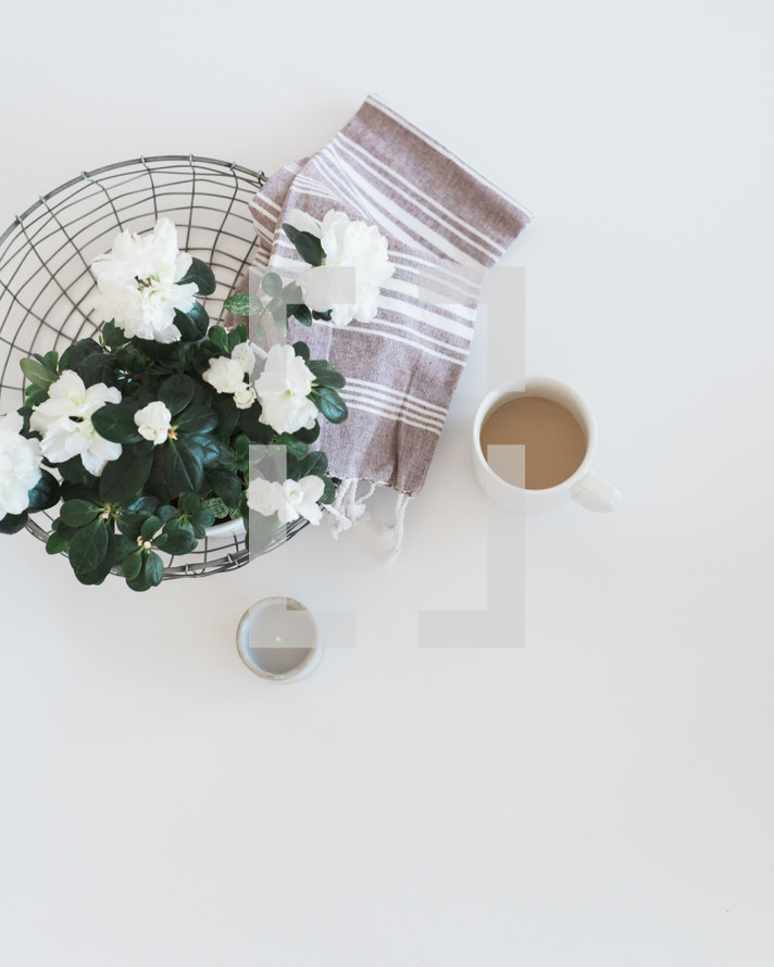 flowers and a towel in a wire basket and a votive 