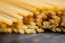 A pile of spaghetti dry on the table. Against a dark background. High quality photo