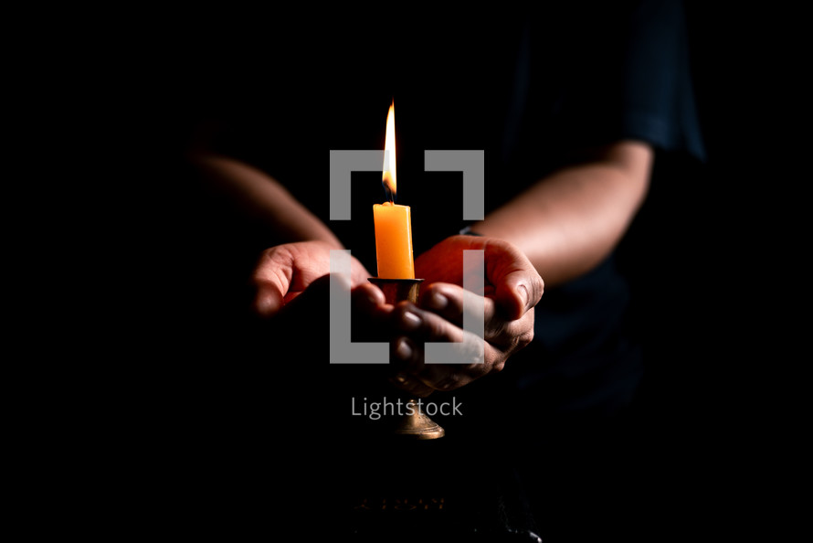 Bible and candlelight with praying hands