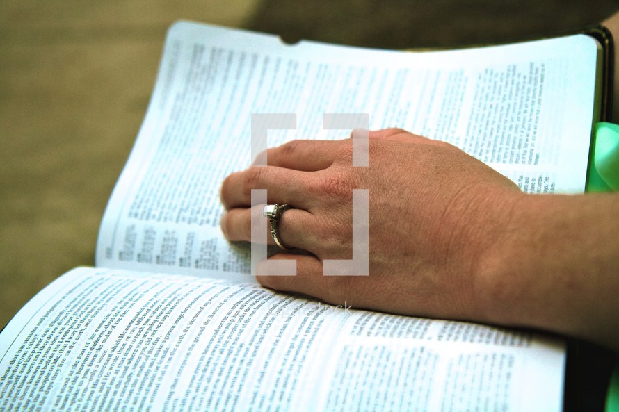 hand on the pages of a Bible