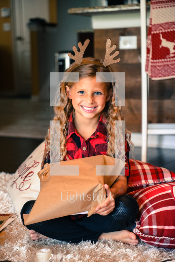 smiling little girl holding a Christmas present 