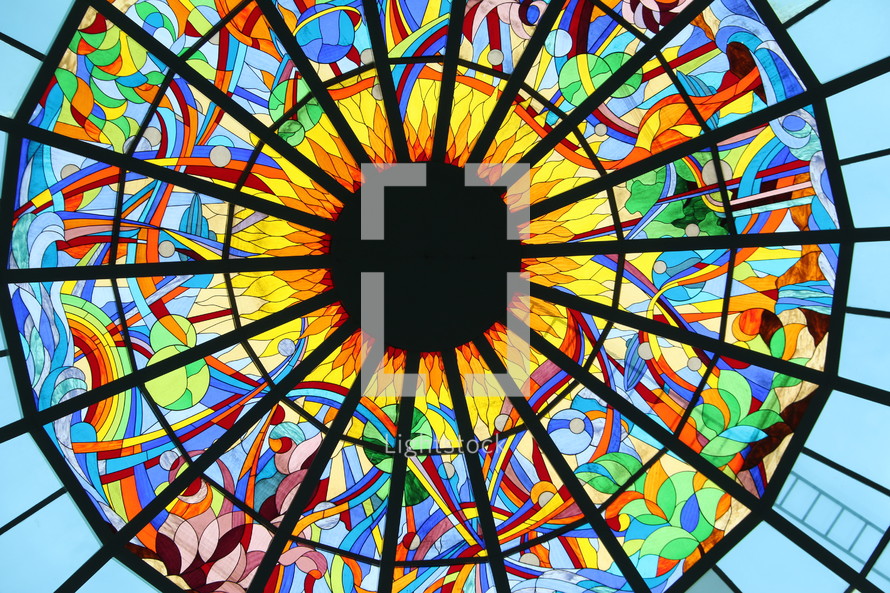 Stained glass window showing the sun, rainbow, seas and creation