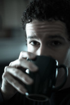 man drinking from a coffee cup