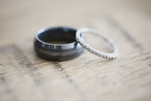 Close up of two wedding bands on a wood table.