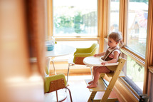 a toddler girl in a highchair 