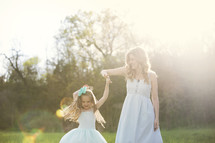 mother and daughter dancing under sunlight 