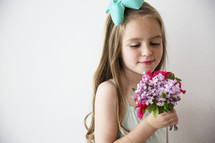A little girl holding a bouquet of flowers.