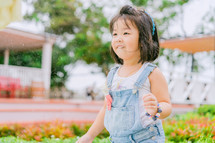 toddler girl gardening in overhauls 