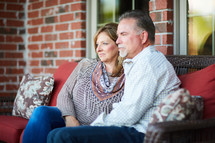 a couple sitting together on a porch 