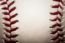 closeup of a baseball with red seams.