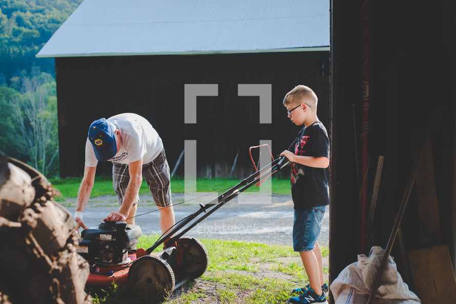 grandfather and grandson fixing a lawnmower 