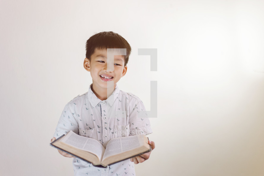 smiling boy holding a Bible 
