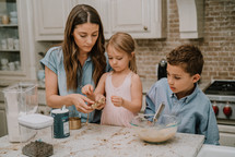 a mother baking cookies with her kids 