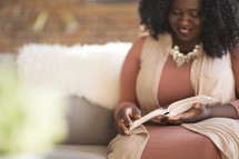 woman sitting on a Bible reading a Bible 