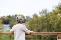 a woman standing looking over a railing 