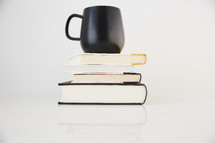 coffee mug on a stack of books 