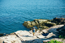 a man standing on a rocky shore looking at the camera 
