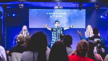 people on stage singing at a worship service