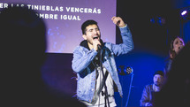 people holding a microphone and singing during a worship service 