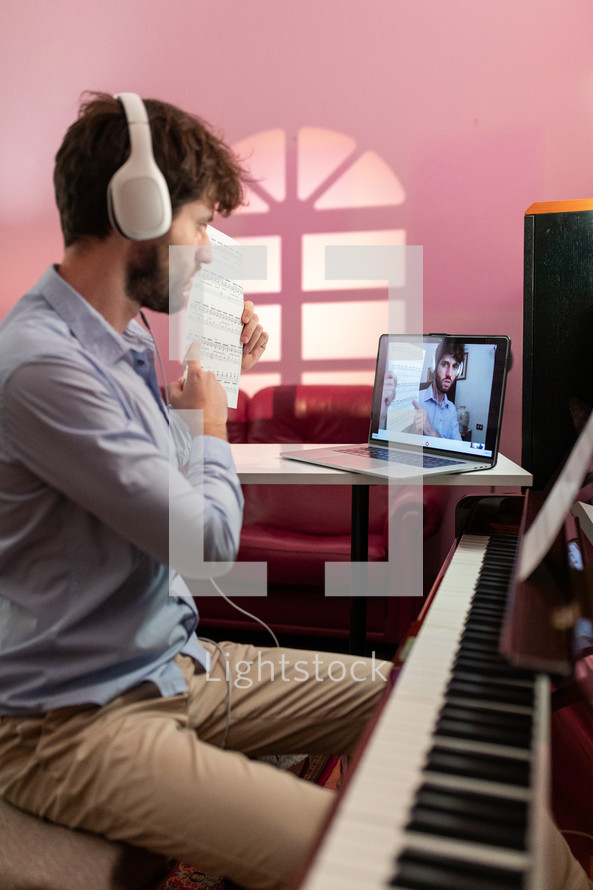 Boy teaching piano lessons with remote computer video call