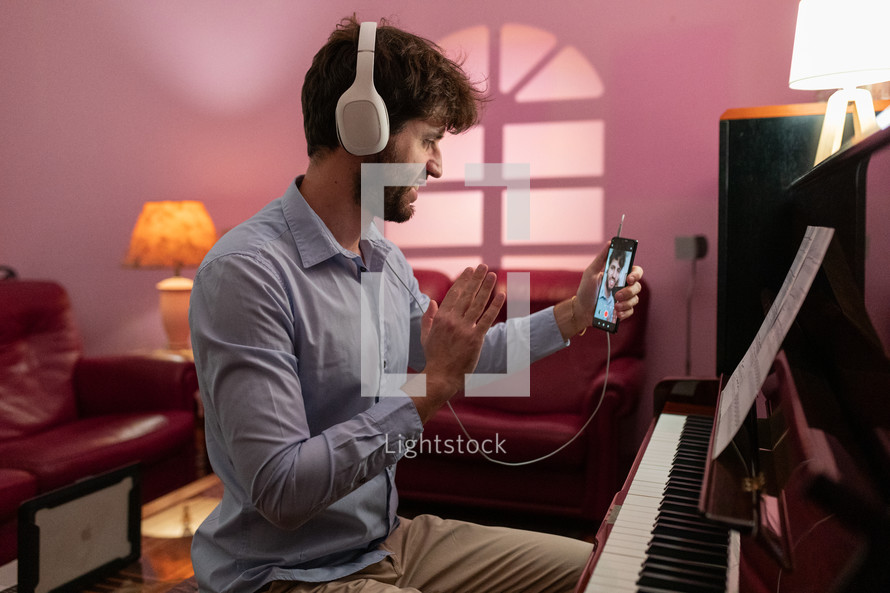 Boy teaching piano lessons with remote smartphone connection