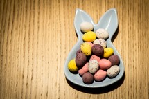 Mini chocolate easter eggs on a bunny shaped bowl