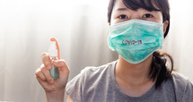woman in a mask with sanitizer 