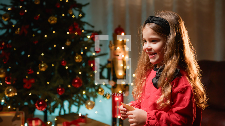 Little girl smiling under the Christmas tree