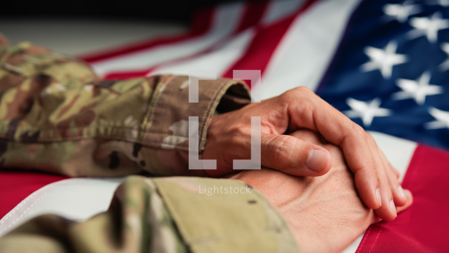 Military man in Uniform touching USA flag with his hand