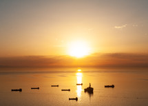 boats on a calm sea at sunset 