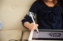 a girl drawing on an iPad 