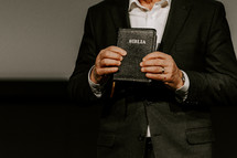 Pastor holding up a Spanish Bible during a sermon.